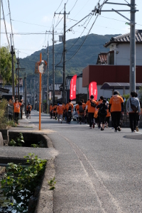 オレンジ色の服を着た人が団地を走っている写真