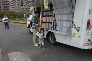 移動図書館で本を選ぶ親子の写真