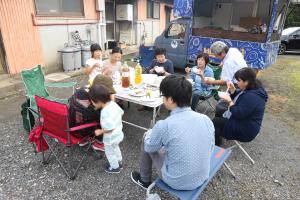 写真：うべ暮らし交流カフェを屋外で開催し、参加者がテーブルを囲んでの談笑