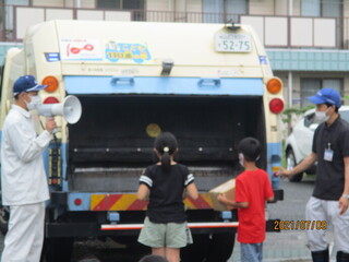 生徒がゴミ収集車にごみを入れている様子